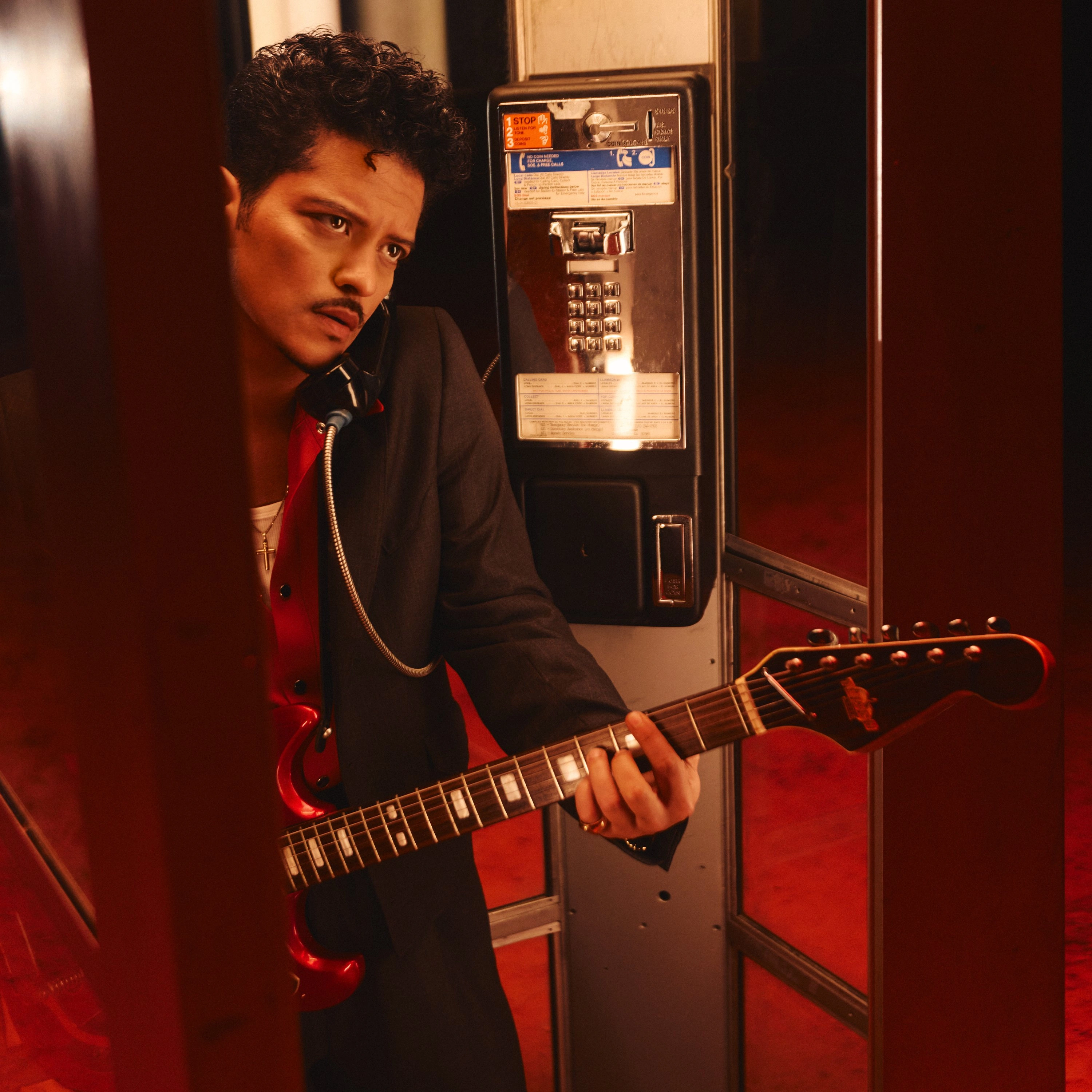 Bruno Mars z gitarą w budce telefonicznej w teledysku Dance With Me
