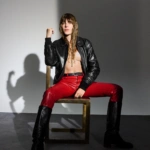 Lou Doillon siedząca na krześle w czerwonych skórzanych spodniach i czarnej kurtce – fotografia prasowa Camille Vivier